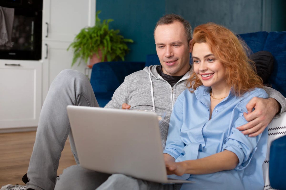 couple dmiling looking at a computer