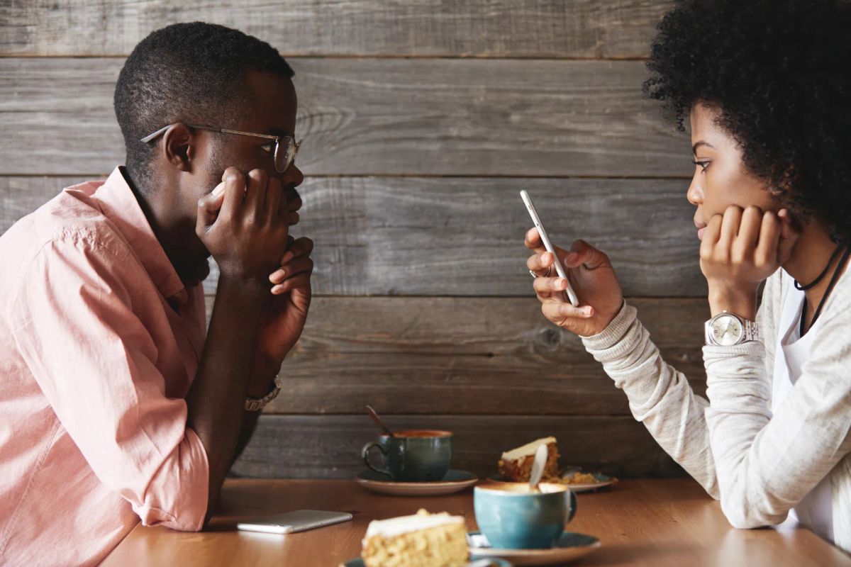 Couple sitting together but feeling emotionally disconnected during conversation